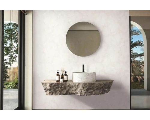 Moderní koupelna s kulatým zrcadlem, kamenným umyvadlem a pečujícími produkty