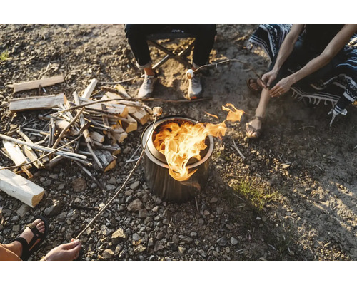 Lidé sedí kolem ohniště a opékají si marshmallows
