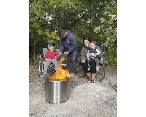 Rodina opéká marshmallows nad venkovním ohništěm.