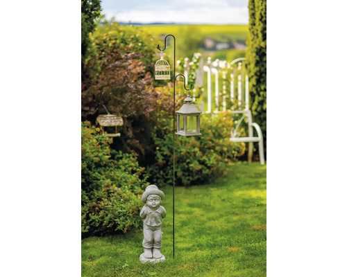 Zahradní scéna s ozdobným sloupem, ptačí klecí, lucernou a figurkou chlapce