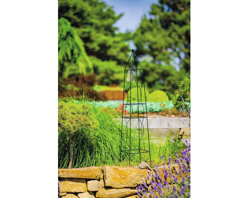 Kovová opora pro popínavé rostliny ve tvaru obelisku v zahradě