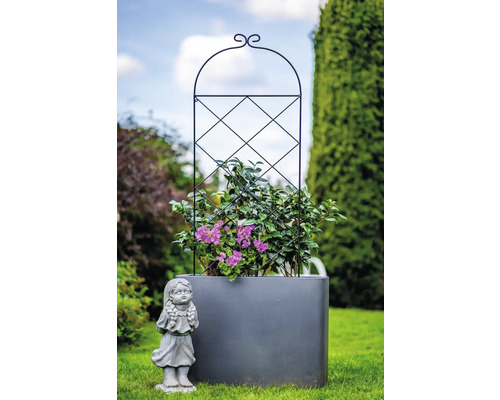 Květináč s mřížovím a figurkou dívky na zahradě
