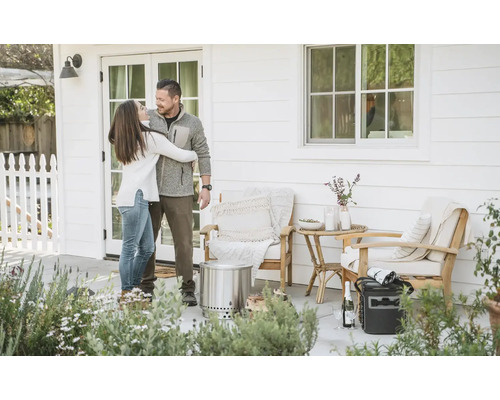 Pár se objímá na terase s nábytkem a ohništěm