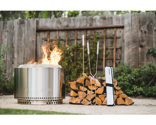 Ohniště Solo Stove s ohněm, poleny a příslušenstvím na zahradě