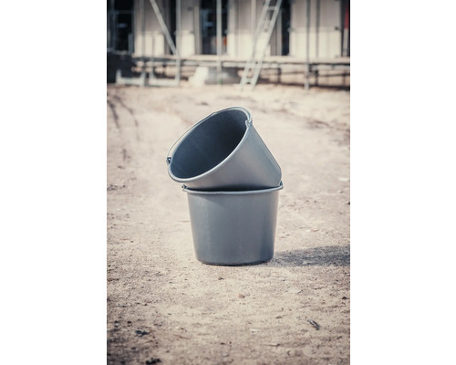 Dva plastové maltovníky naskládané na sobě na staveništi.