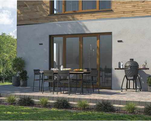 Terasa s zahradním stolem, židlemi a keramickým grilem u obytného domu