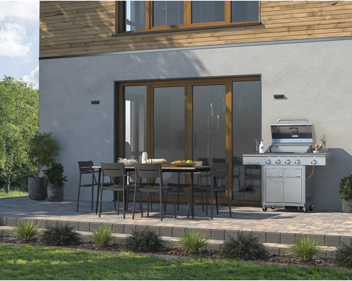 Venkovní prostor s grilem, zahradním stolem a židlemi před domem