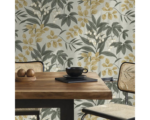 Dekorativní pokoj s jídelním stolem před tapetou se vzorem listů.