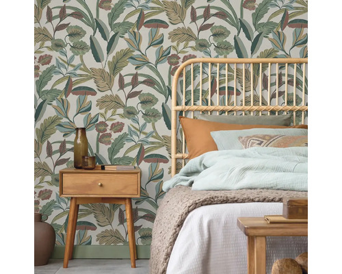 Ložnice s tapetou s motivem džungle, ratanovou postelí a dřevěným nočním stolkem