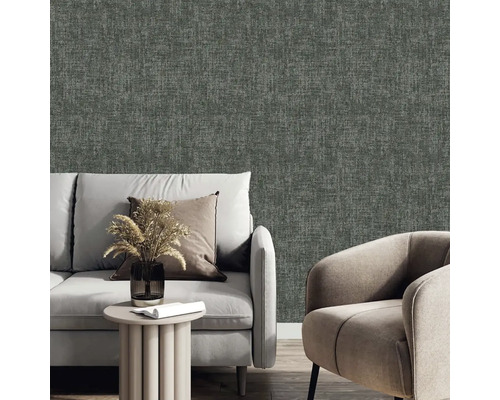 Obývací pokoj s šedou textilní tapetou, pohovkou a křeslem.