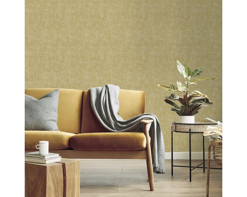 Obývací pokoj se žlutou pohovkou, stolem a pokojovou rostlinou před vzorovanou tapetou