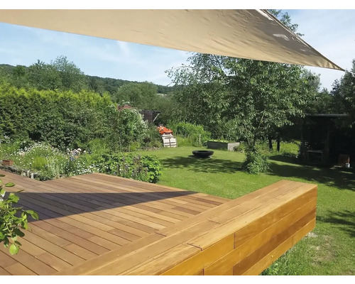 Dřevěná terasa v zahradě se sluneční plachtou a trávníkem