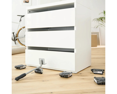 Sada nábytkových válečků se zvedákem a komodou na dřevěné podlaze