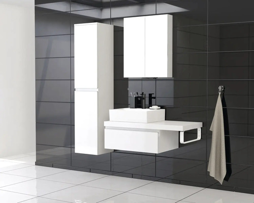 Moderní koupelna s bílým koupelnovým nábytkem, sestávající z umyvadla, spodní skříňky, zrcadlové skříňky a vysoké skříňky na tmavém obkladu.