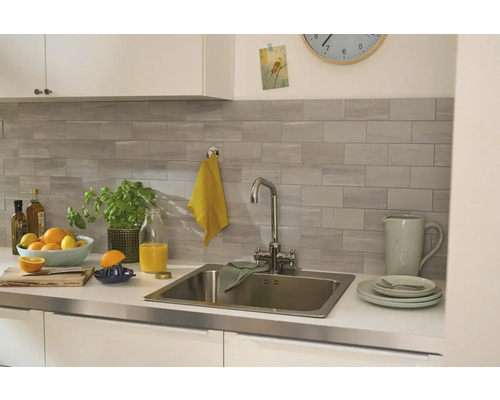 Světlá kuchyň s dřezem, baterií a kuchyňským náčiním