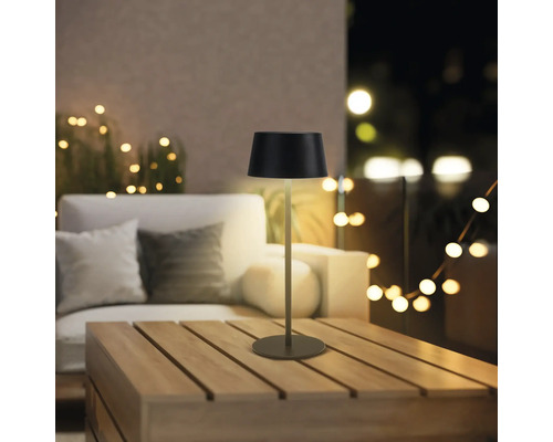 Dekorativní stolní lampa na dřevěném stole venku