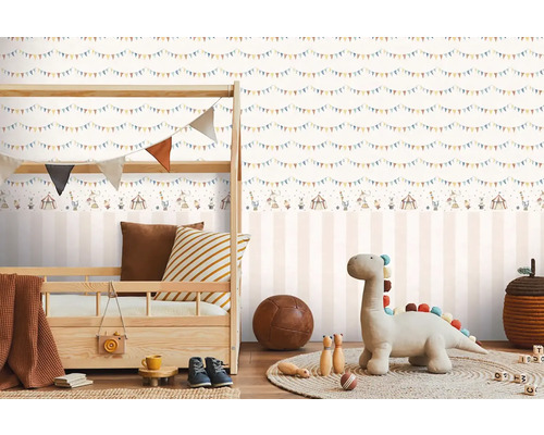 Dětský pokoj s dětskou postelí a pruhovanou tapetou s motivem cirkusu