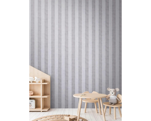 Dětský pokoj s pruhovanou tapetou, stolem, židlemi a regálem