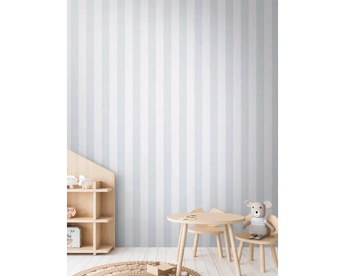 Dětský pokoj s pruhovanou tapetou, stolem a židlemi