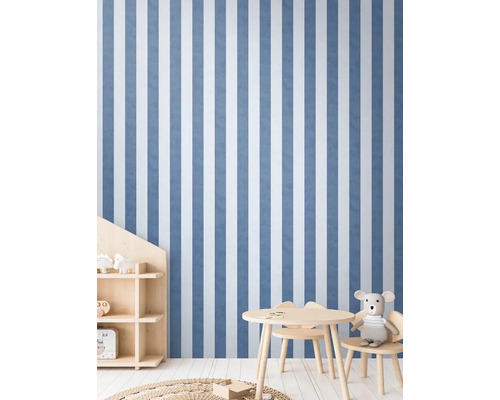 Dětský pokoj s pruhovanou tapetou, dětským stolem a regálem.