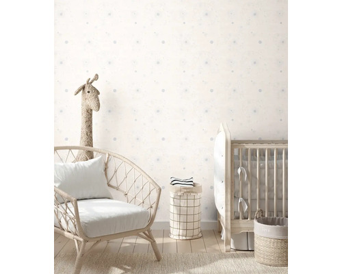 Dětský pokoj s křeslem, dětskou postýlkou a úložnými koši před stěnou s tečkovaným vzorem.