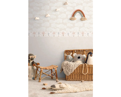 Dětský pokoj s tapetou s motivem oblaků, hračkami a proutěným košem