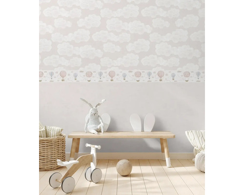 Dětský pokoj s tapetou s motivem oblaků a hračkami