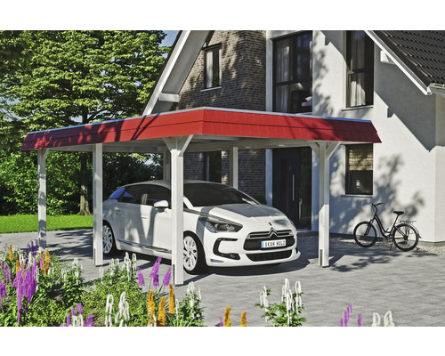 Přístřešek pro auto s červenou střechou a bílým rámem před obytným domem s autem a jízdním kolem