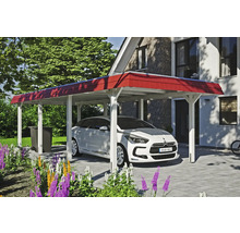 Bílé auto pod přístřeškem pro auto před domem se zahradou