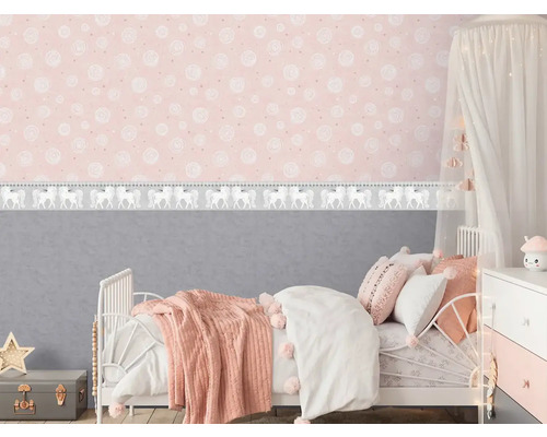 Dětský pokoj s postelí, nočním stolkem a růžovou tapetou se vzorem jednorožce