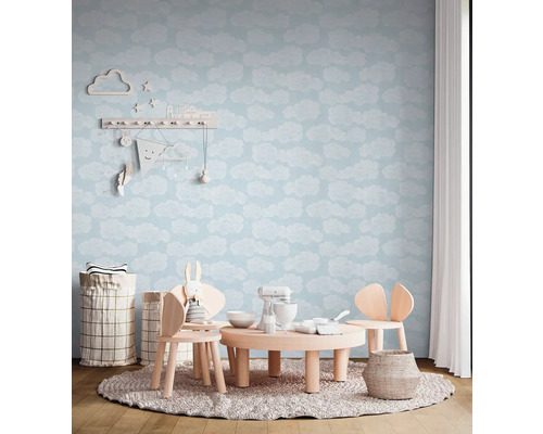 Dětský pokoj s tapetou s motivem oblaků, dětským stolem a židlemi