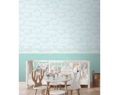 Dětský pokoj s tapetou s oblaky, dětskou postelí a skupinou stolů