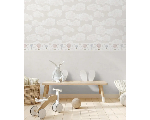 Dětský pokoj s tapetou s mraky a bordurou s horkovzdušnými balóny, zdobený hračkami