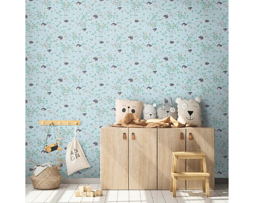 Dětský pokoj s tapetou se vzorem, dřevěnou komodou a dekorativními předměty