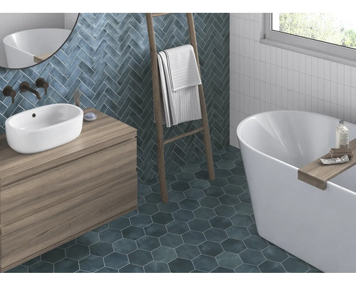 Koupelna s umyvadlem, vanou, žebříkem na ručníky a obklady stěn a podlahy