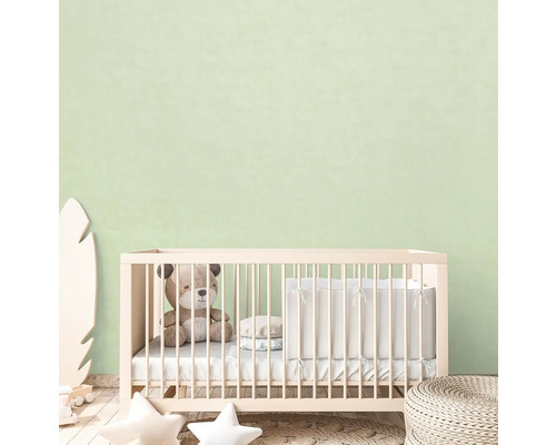 Dětský pokoj s postýlkou, medvídkem a dekorativními prvky.