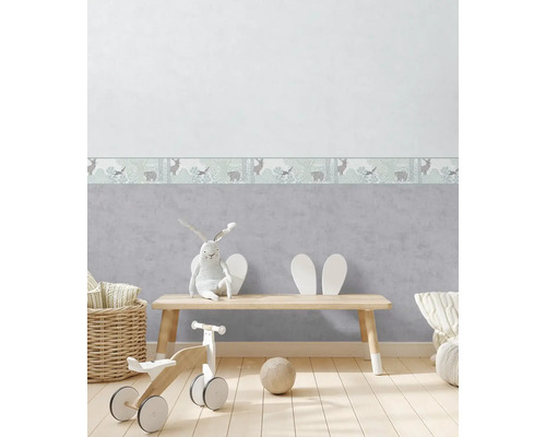 Dětský pokoj s tapetou s lesními zvířaty, dřevěnou podlahou a hračkami