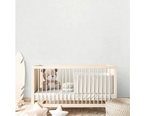 Dětský pokoj s dětskou postýlkou, plyšovým medvídkem a dekoracemi.