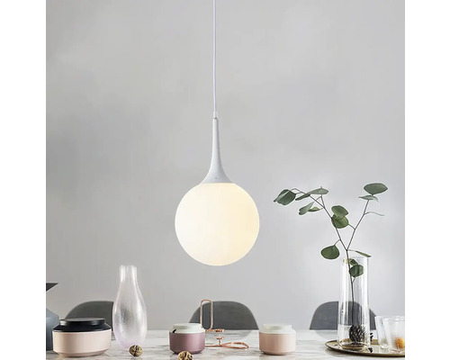 Závěsná lampa s kulatým skleněným stínidlem nad jídelním stolem