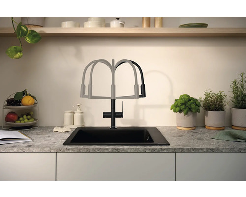 Kuchyňský dřez s vodovodní baterií a výsuvnou hubicí před kuchyňskou zástěnou s bylinkami