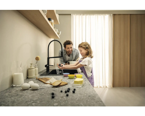 Scéna v kuchyni s otcem a dcerou, kteří myjí borůvky pod kohoutkem, když spolu vaří