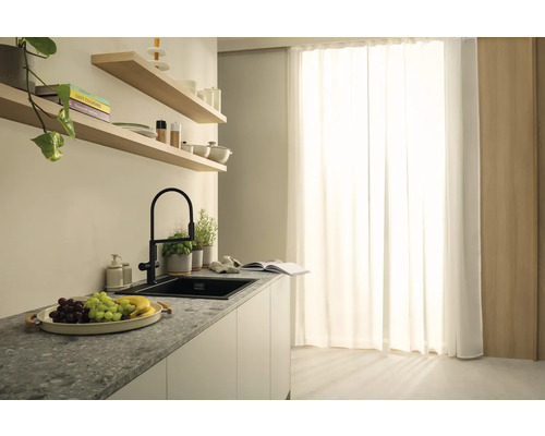 Kuchyňská scéna s dřezem, baterií a dekorativními prvky na pracovní desce