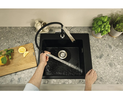 Dřez s vodovodní baterií, krájecí deska a květináče s bylinkami na pracovní desce