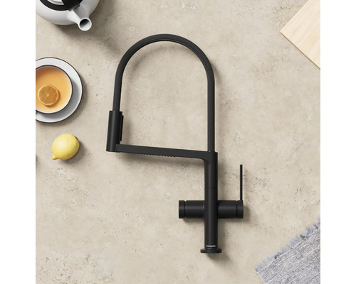 Černá kuchyňská baterie s vysokým výtokem vedle konvice a šálku