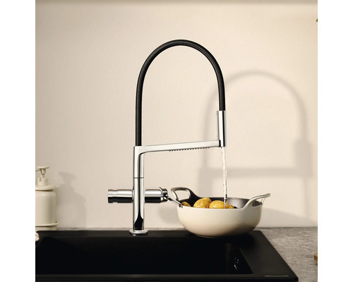 Kuchyňská baterie s flexibilním výtokem nad dřezem s bramborami v sítu