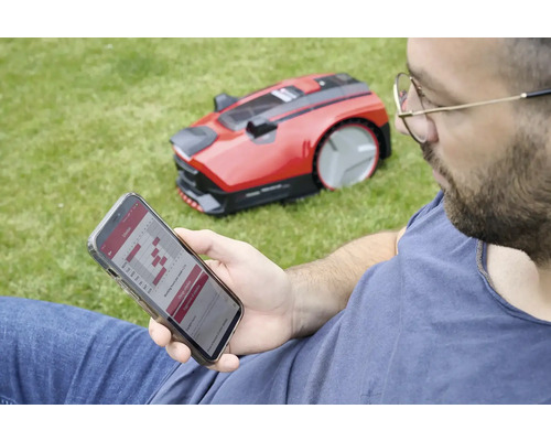 Muž programuje robotickou sekačku přes smartphone