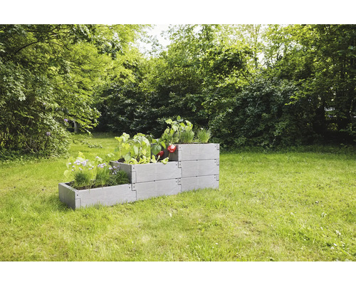 Plastový vyvýšený záhon s rostlinami na zahradě