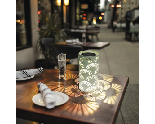 Dekorativní solární lampa na stole ve venkovním prostředí.