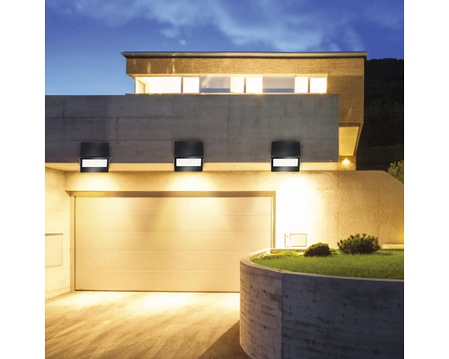 Fasáda domu s garáží a třemi černými nástěnnými svítidly