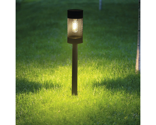 Dekorativní zahradní lampa z kovu na trávníku.